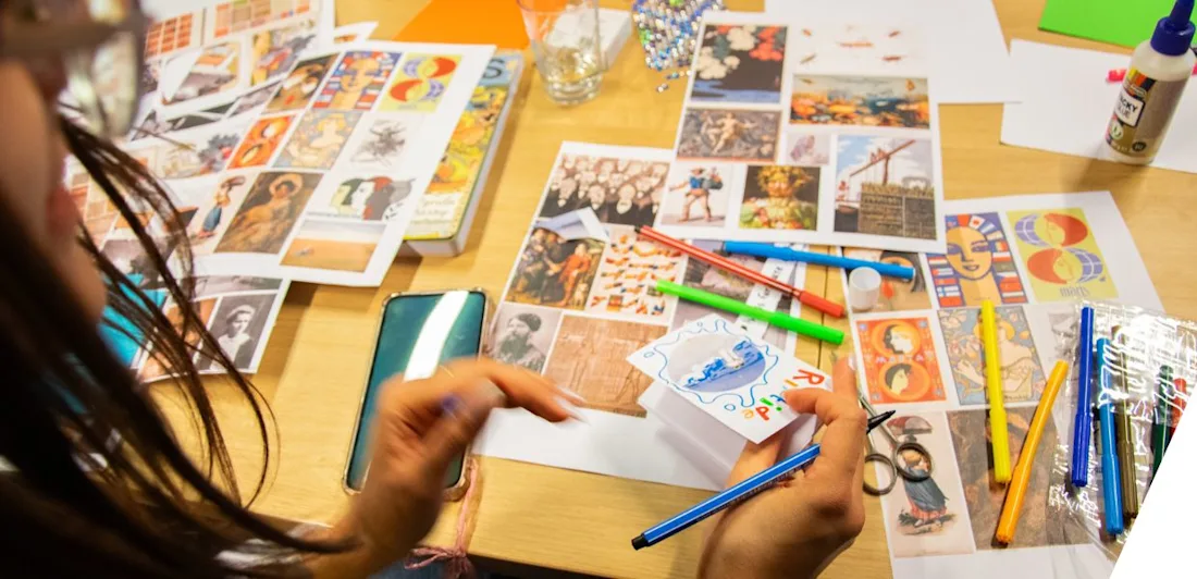 Photograph of images and pens being used to make magazines