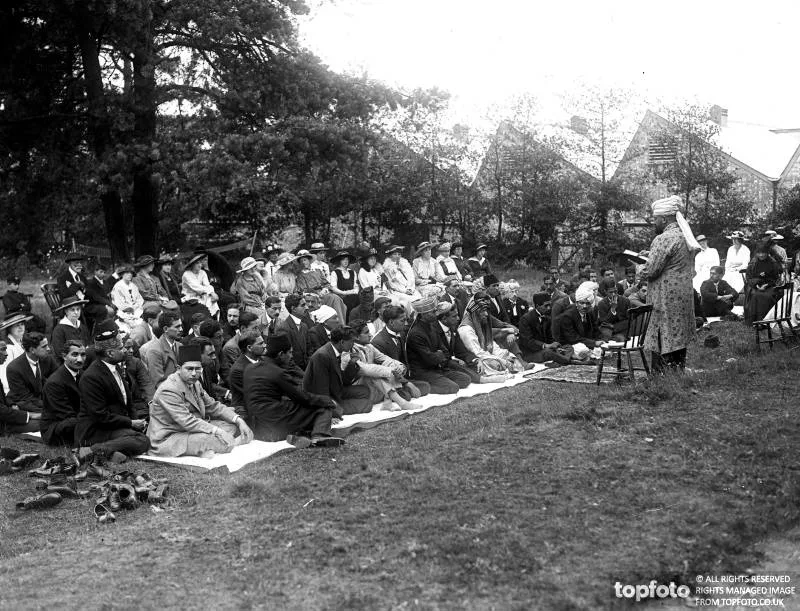 black and white photograph, a man preaching to a large group of people 