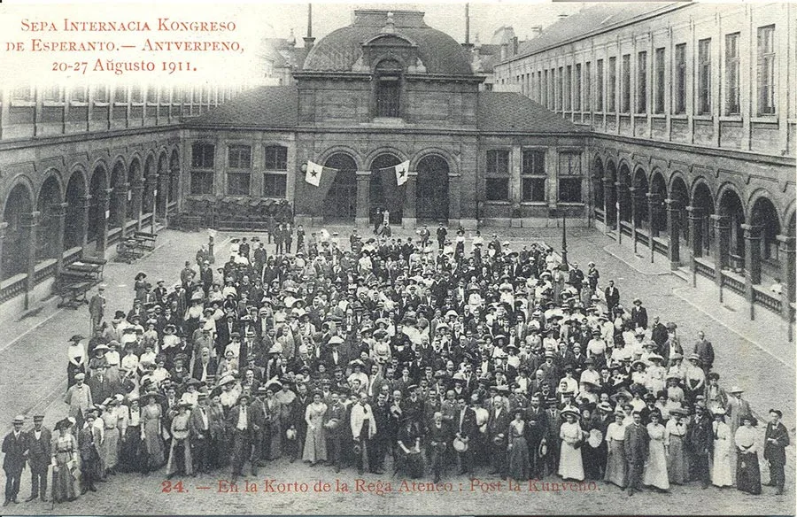 black and white photograph, a large group of people photographed in a building courtyard