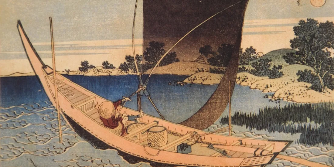 A small sailing boat on water beside a shoreline