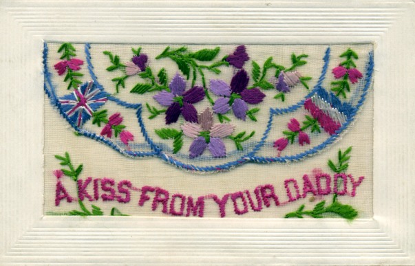 an embroidered card with words 'a kiss from your daddy' and flower design