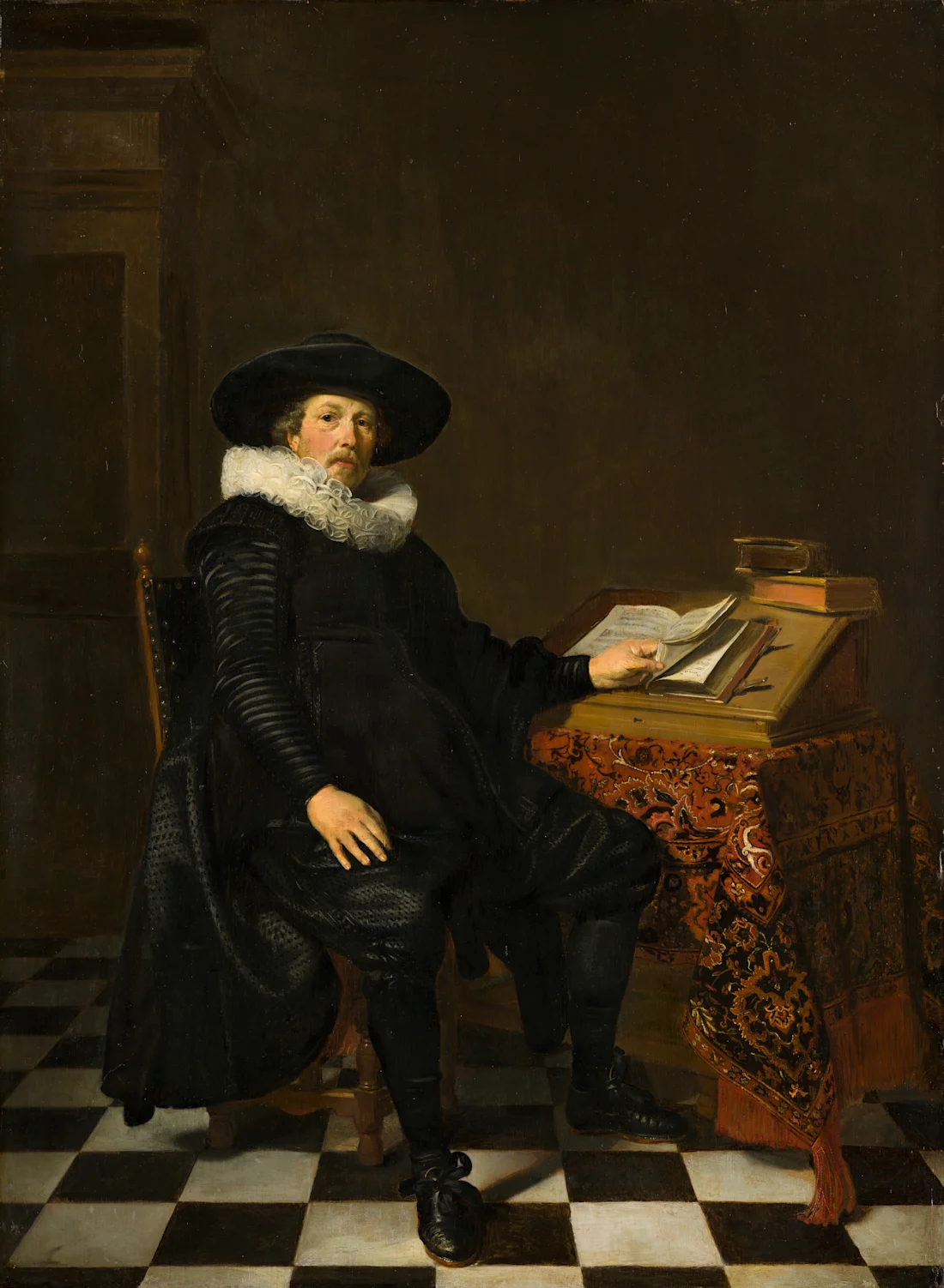 A man in black 17th-century attire sits at a desk with books on a checkered floor.