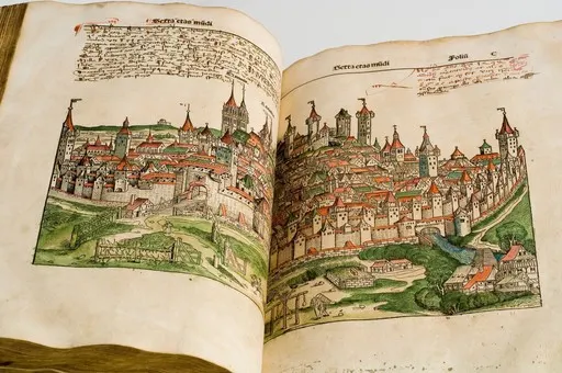 Open ancient book showing colorful, detailed illustrations of a walled medieval city with towers and houses.