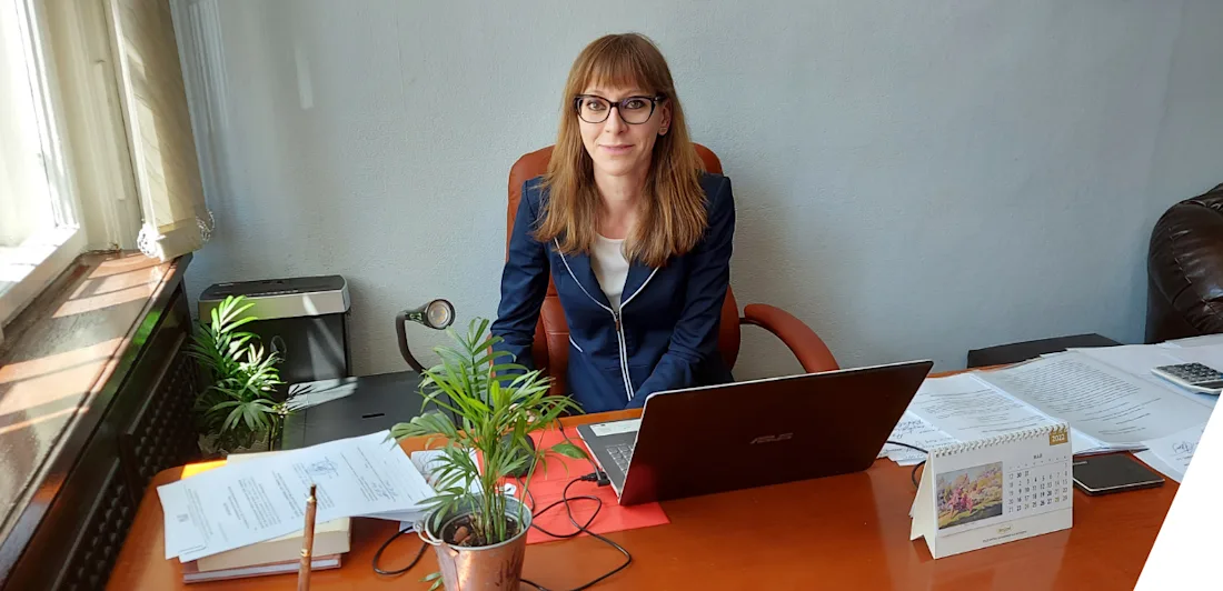 A photograph of Alexandra Milanova sat at her desk