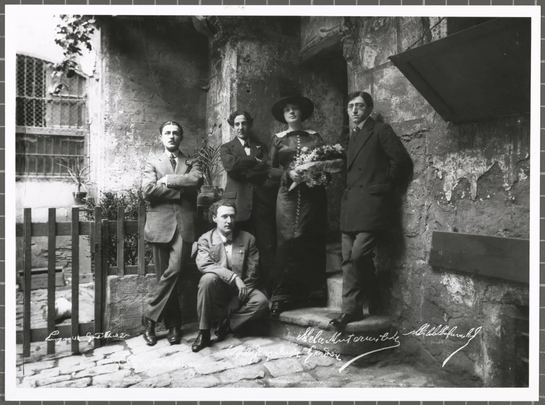 black and white group photograph of five people standing outside a building