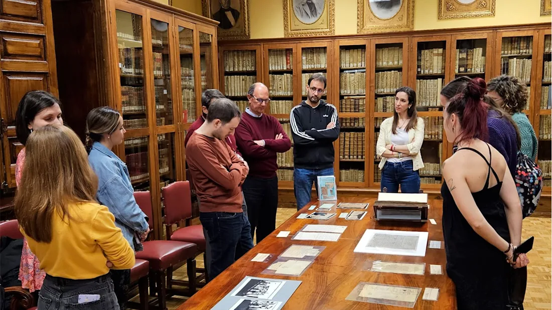 Participants visit Spain's National Archive, viewing documents on a large table 