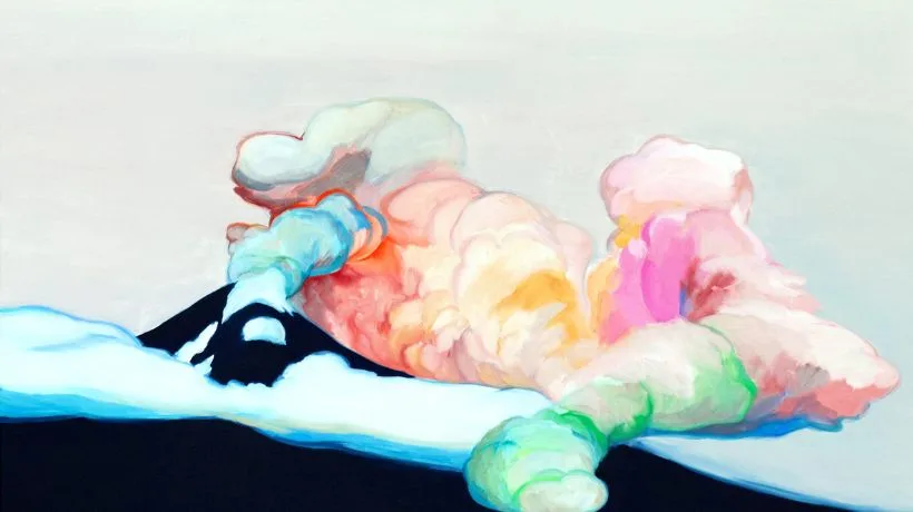 Colorful smoke billows from a dark mountain peak under a light sky, with snow on the mountains slope.