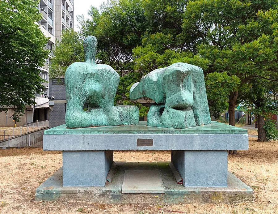green-tinged sculpture among high-rise buildings