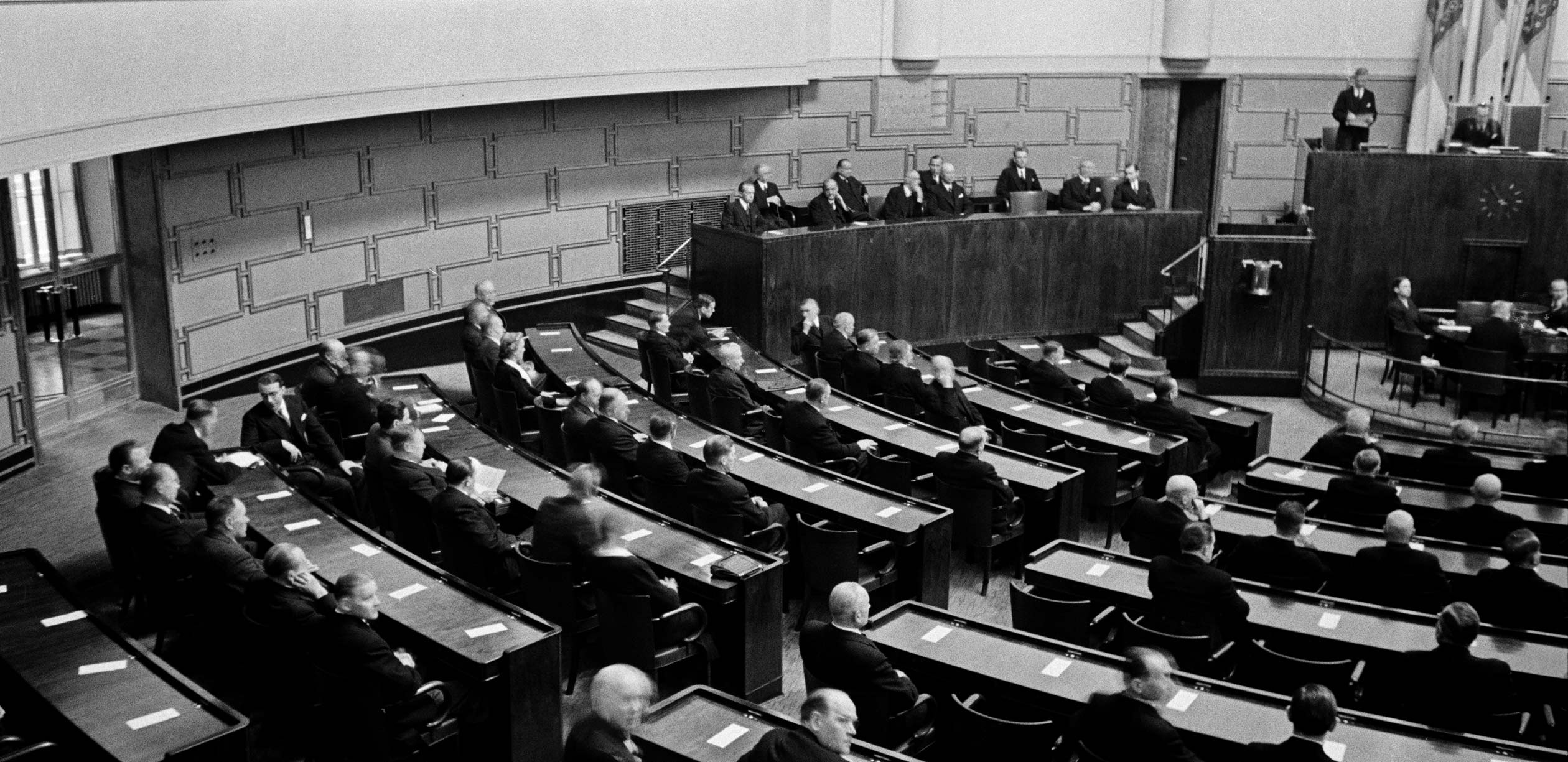 black and white photograph, people sitting in a parliament.