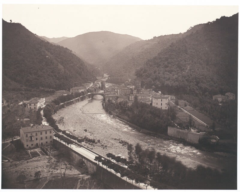 black and white panorama photograph of a town by a river