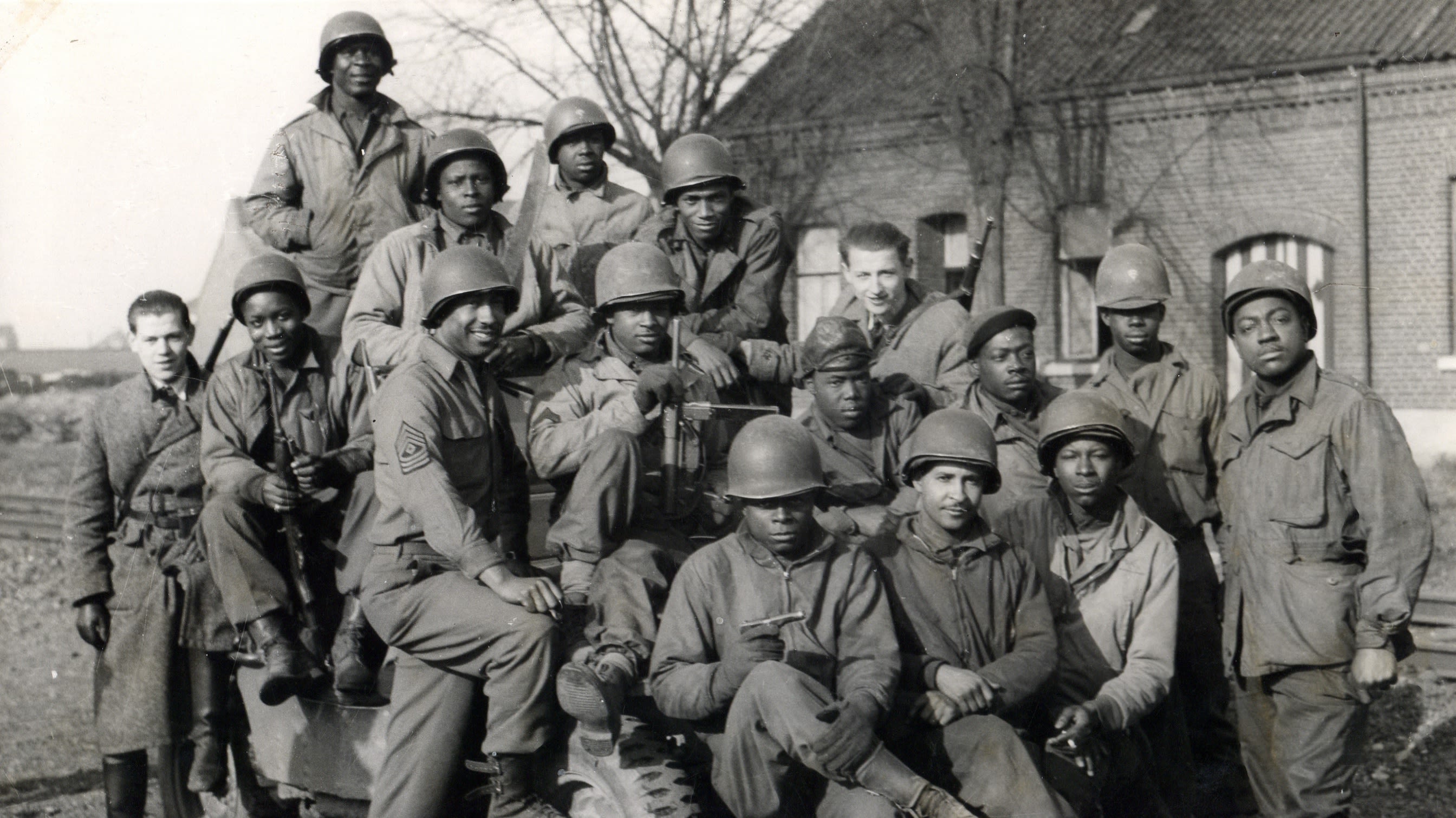 black and white photograph, a group of African American soldiers along with two white men.