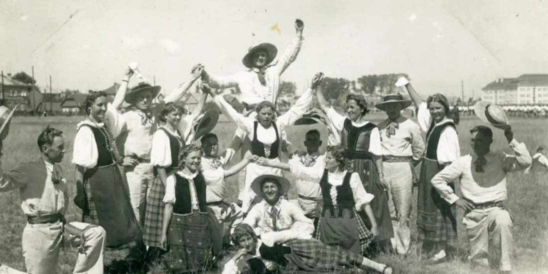 A photograph of dancers standing in a field