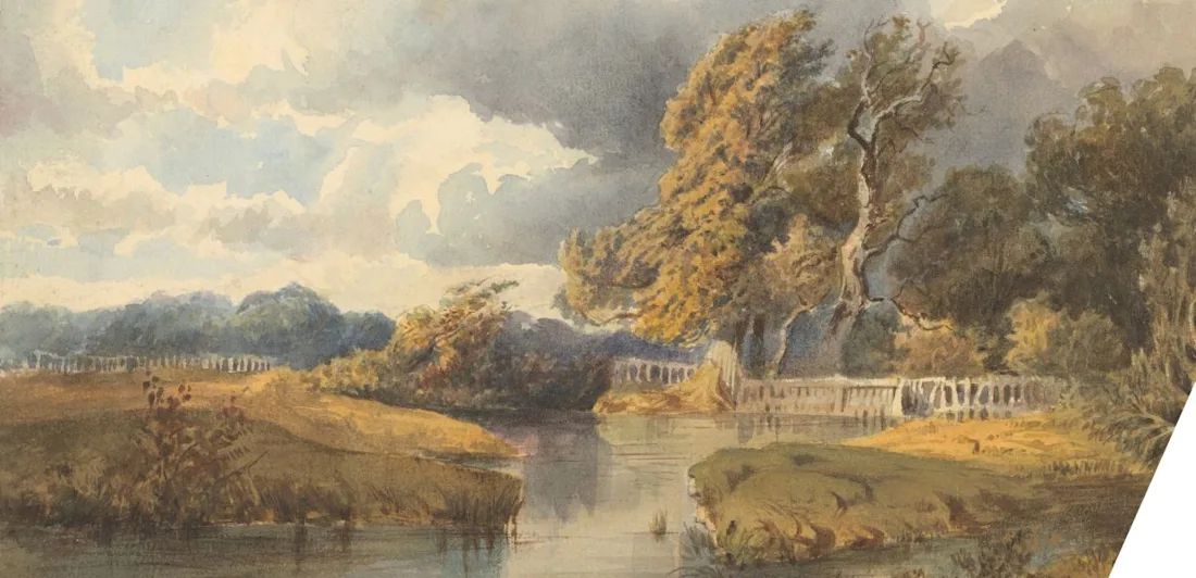 A lake in a park with windswept trees and a dramatic, cloudy sky