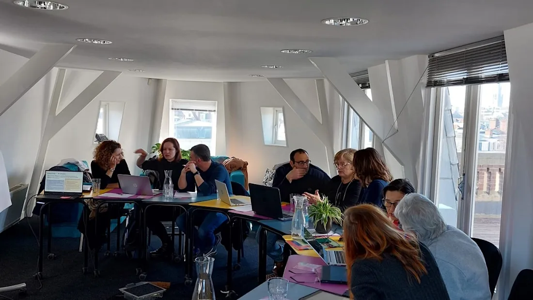 A group of people sat around a curved table in discussion