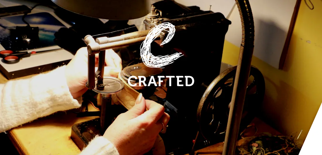 Hands using a sewing machine to make gloves