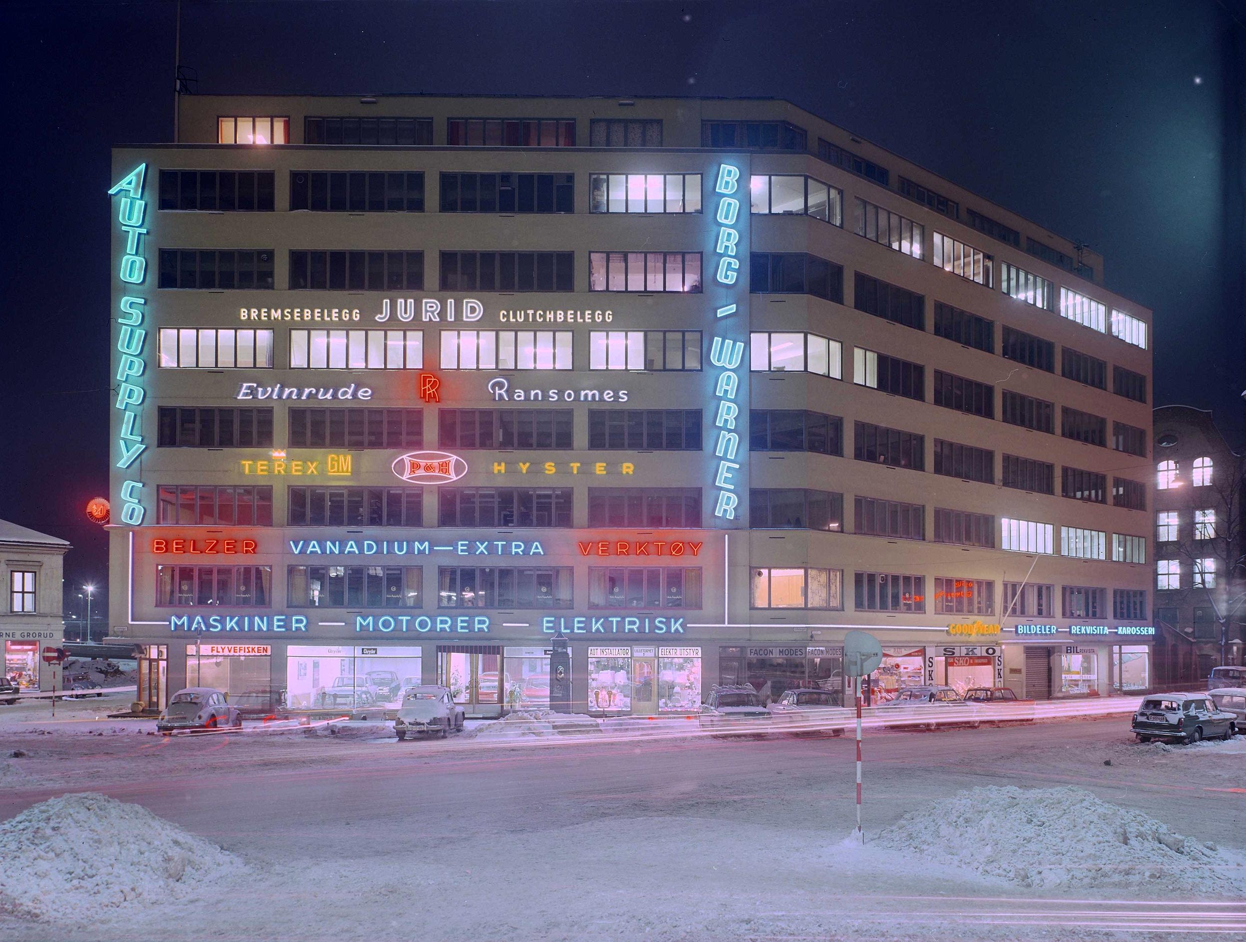 colour photograph, a building at night lit up by neon signs.