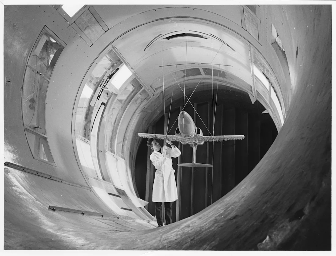 A person working on a model aeroplane in a tunnel