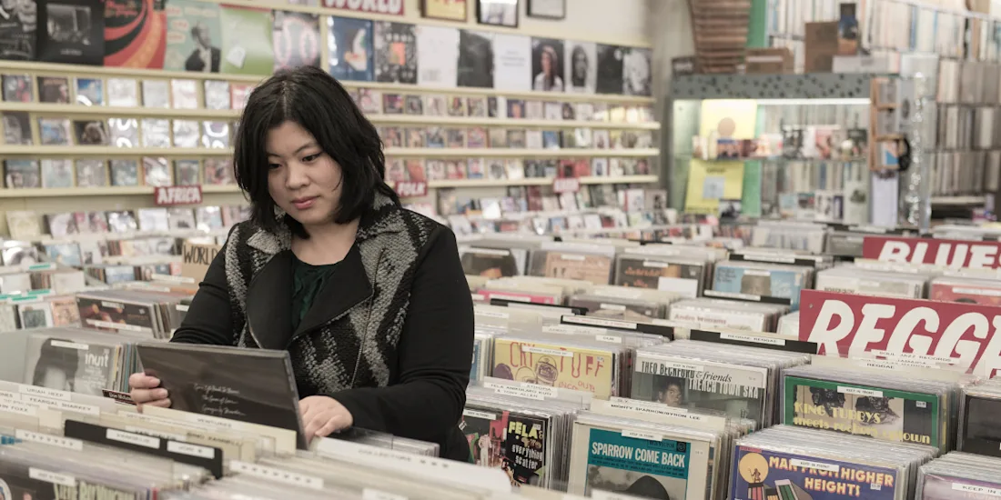 A photograph of Dr Cynthia Liem browsing records in a shop