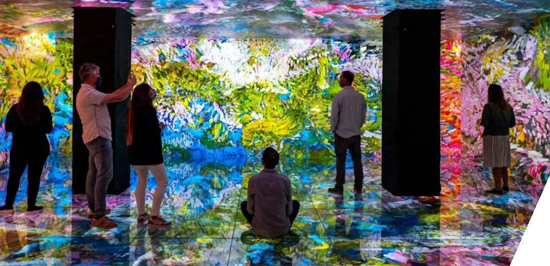 Five people stand, and one sits on the floor, of the Gaudí Cube,  the first six-sided LED cube in the world, which presents the work of the digital artist Refik Anadol