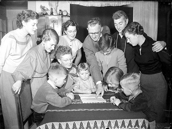 family standing around table looking at map