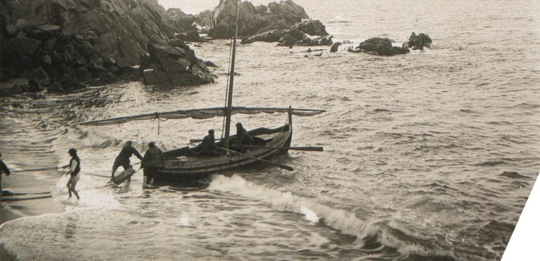 People launching a boat into the ocean