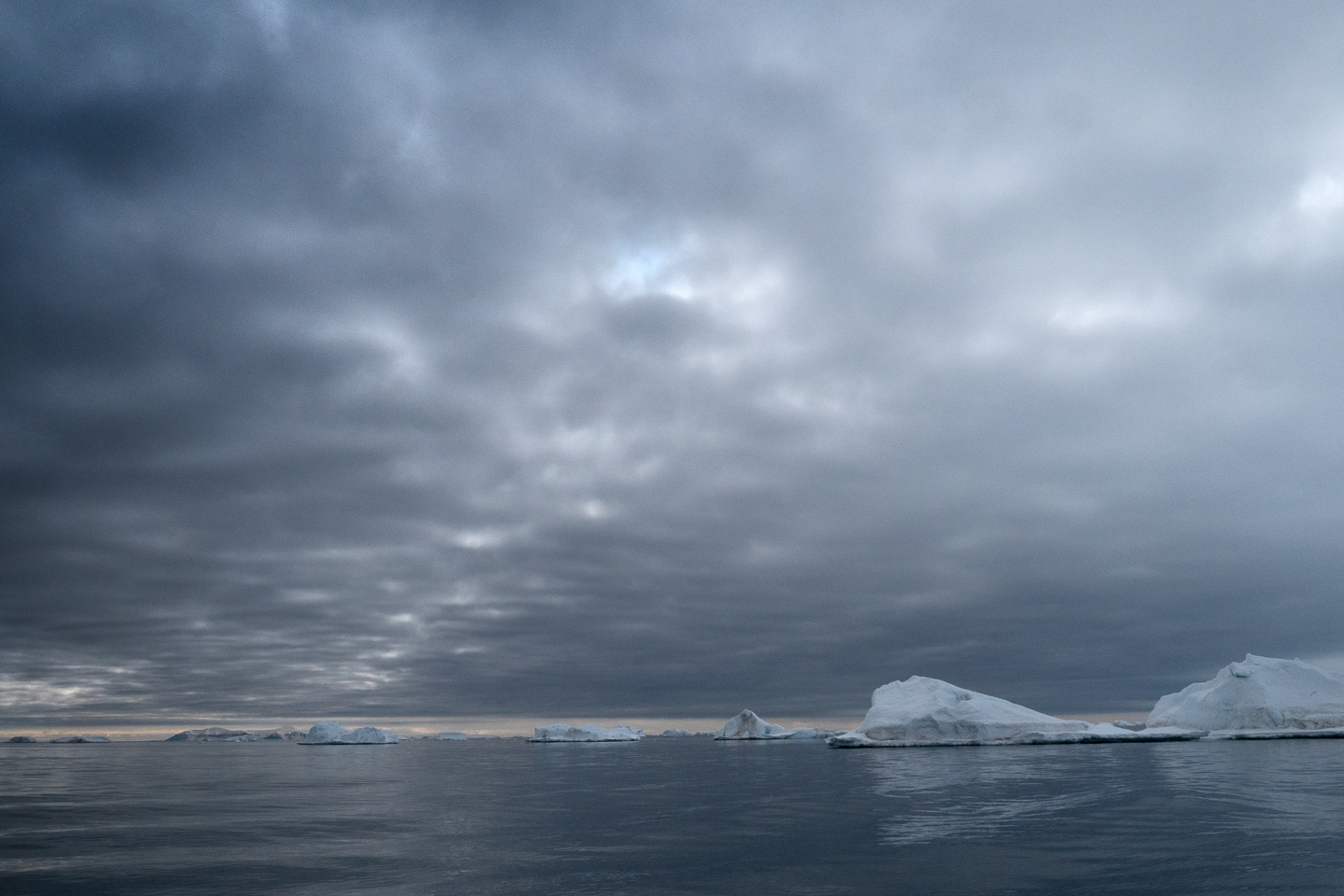 Dark clouds cover sky above melted ice floes in Svalbard