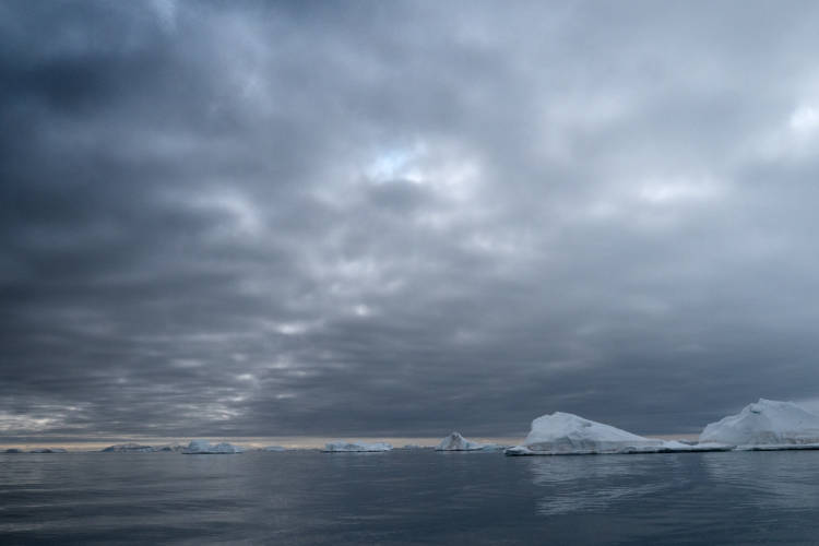 Dark clouds cover sky above melted ice floes in Svalbard