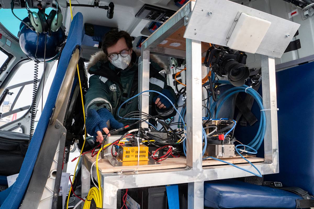 A student from Simon Fraser University sets up the SAR technology in a helicopter.