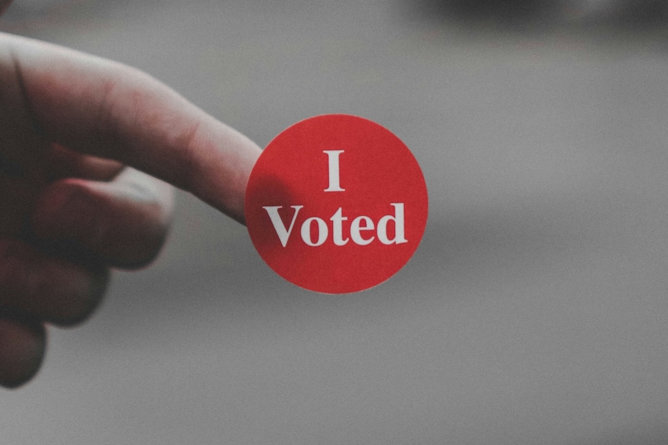A sticker saying, "I Voted" on the end of a person's finger