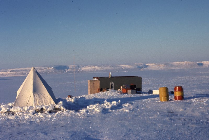 A cliff-side observation cabin and sleeping tent on Cape Liddon, Devon Island, in spring.