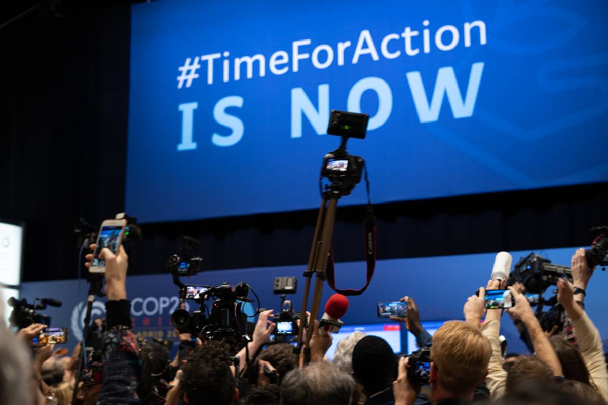 media cameras shooting a stage with "#TimeForAction is now" being showcased image