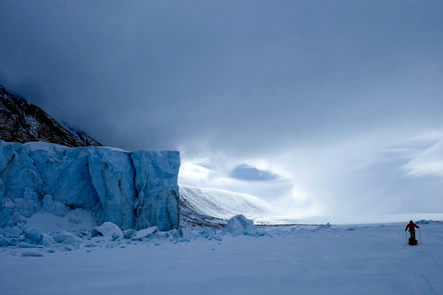 Frank Wolf skis along the sea ice past the toe of the Sverdrup Glacier