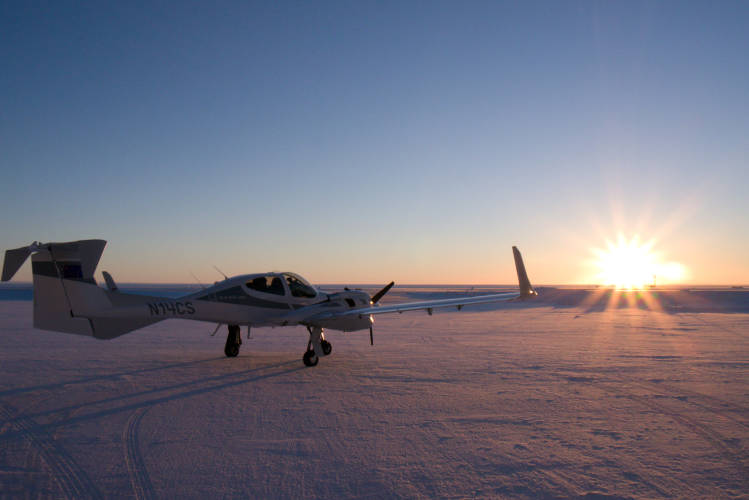 A plane on the runway in the Alaskan sunset