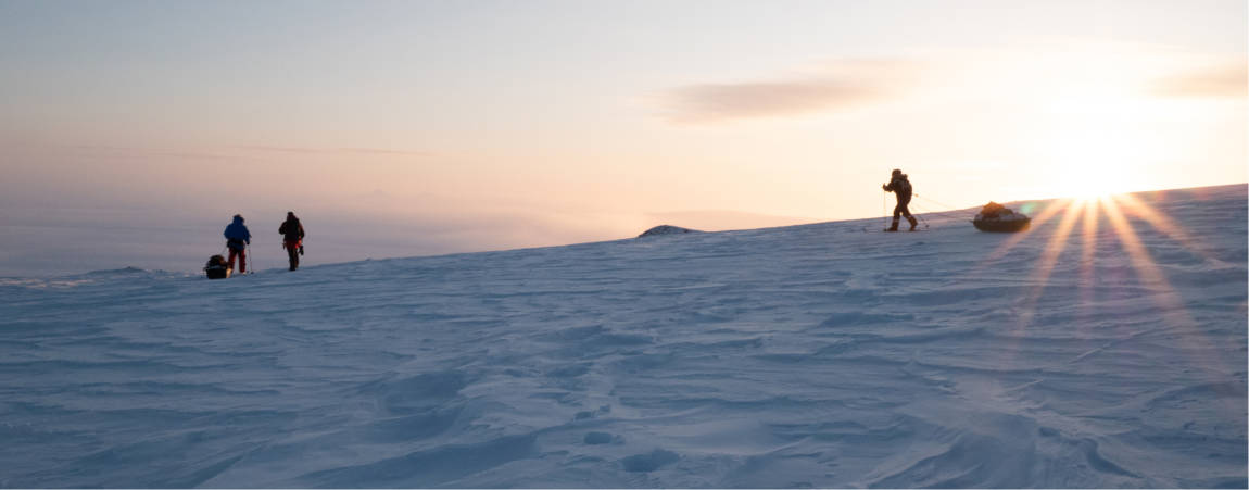 PBI Researchers skiing across Arctic snow at sunrise