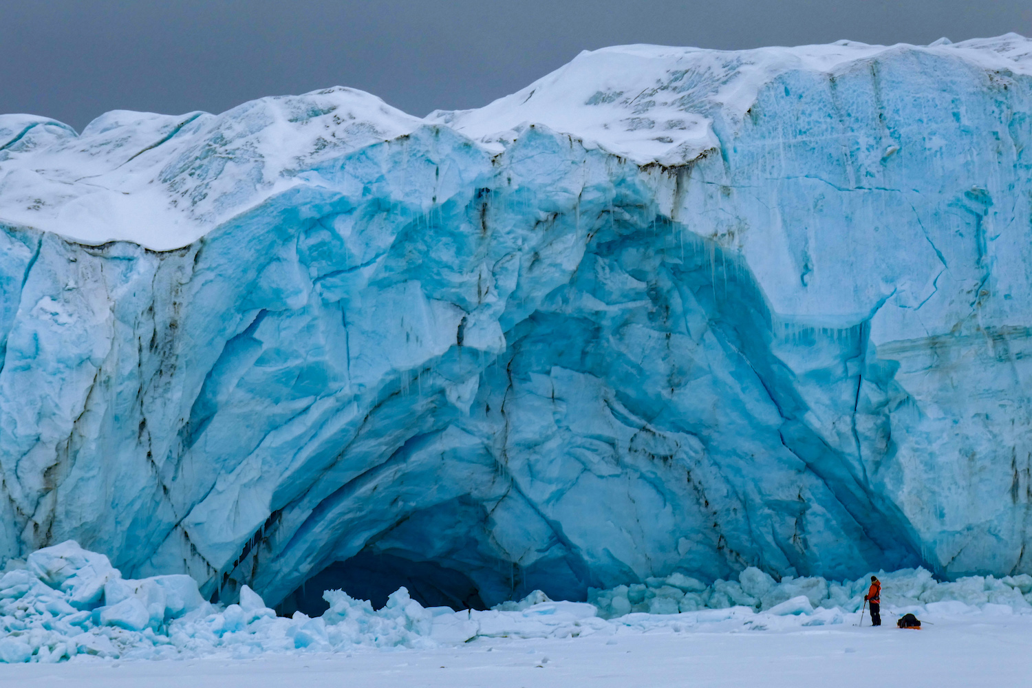 Frank Wolf looking very small beneath an impressive ice cave