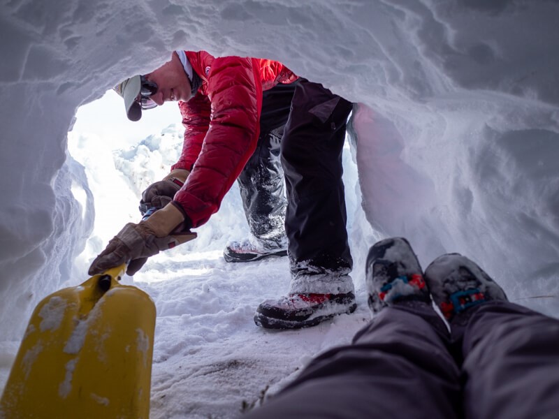 Polar Bears International staff member BJ Kirschhoffer shown excavating an artificial den for the SAR test