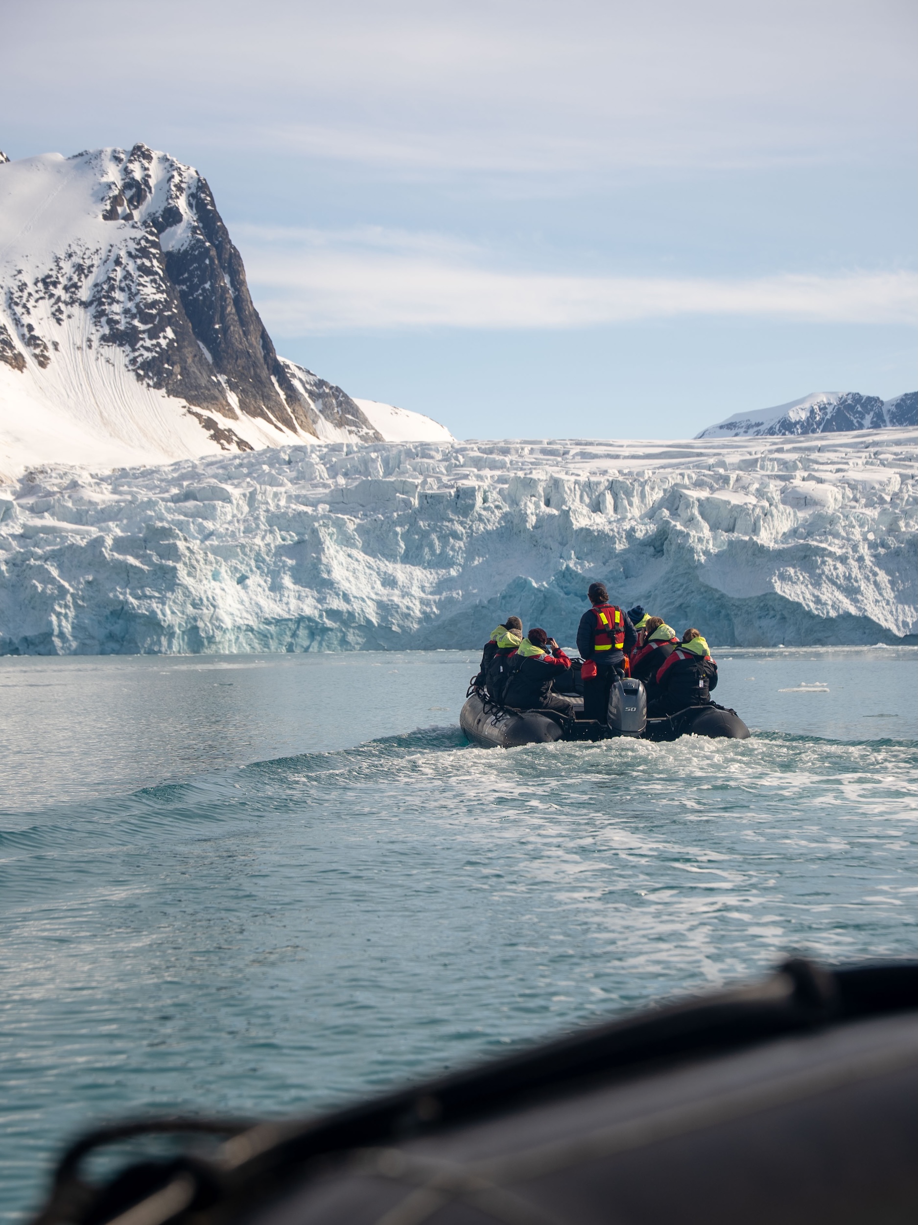 A guide leads a tour group on a zodiac boat in Svalbard, Norway