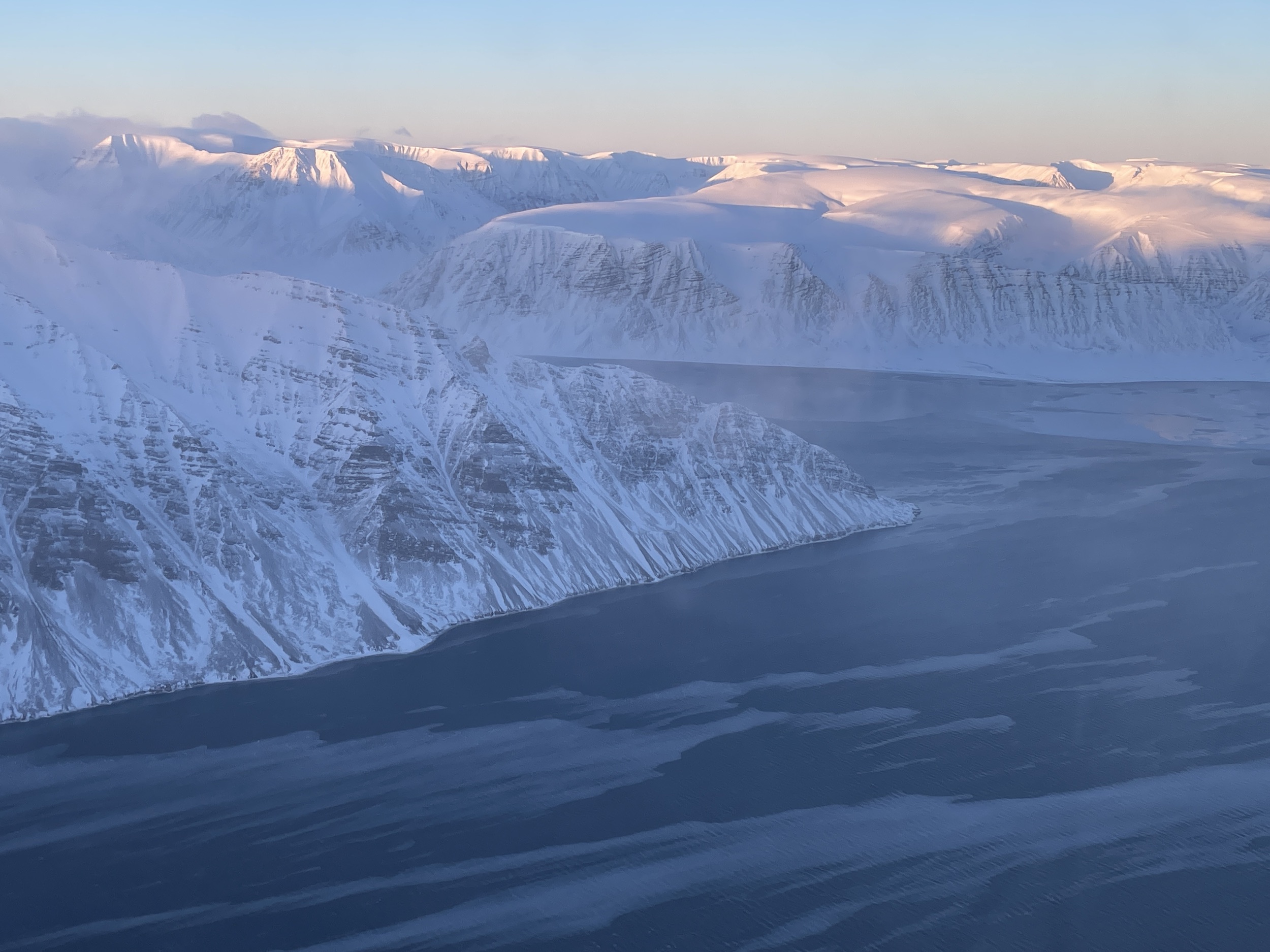 Aerial image of Svalbard mountains and water in winter