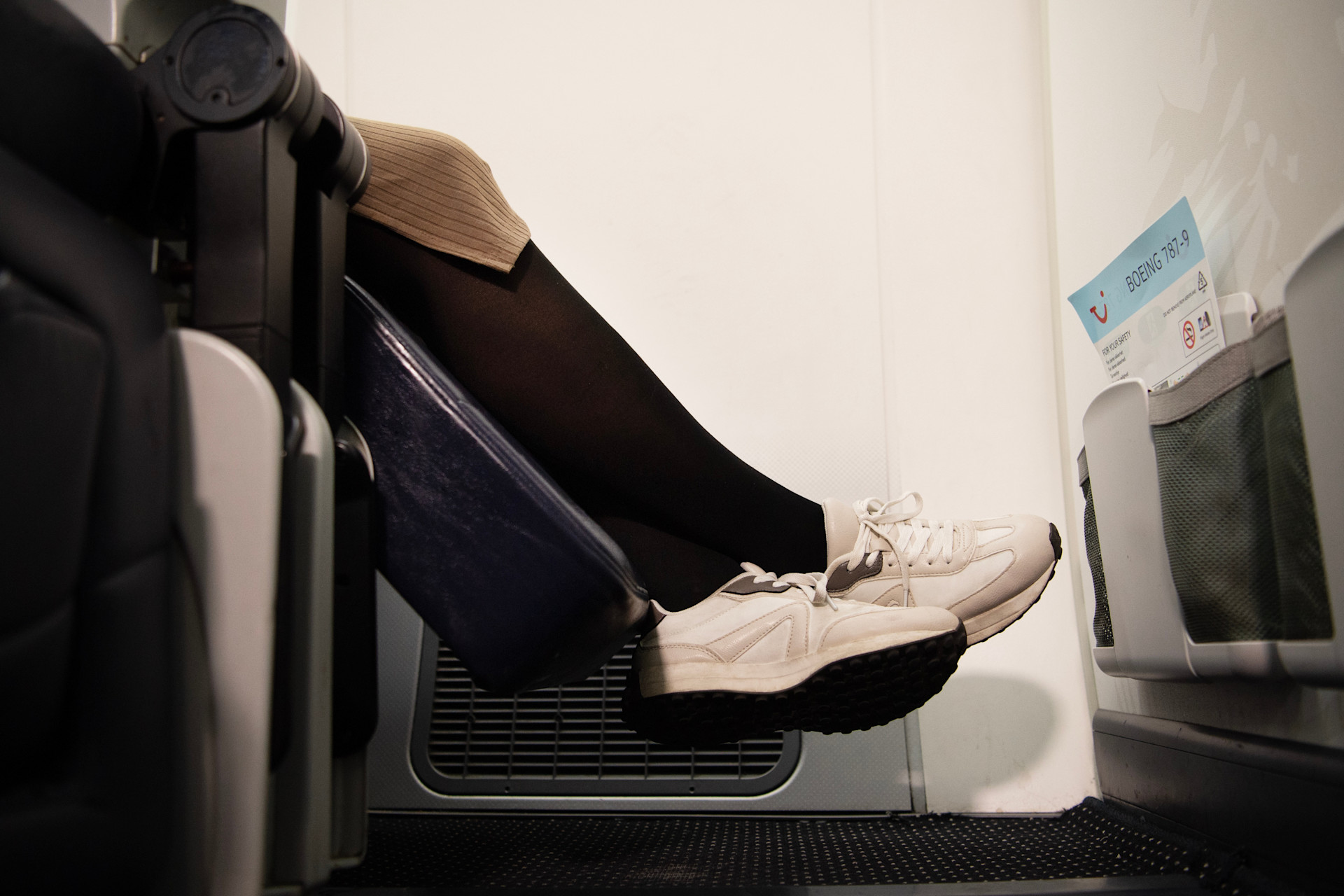 Mies avustetaan pyörätuolissa omalle istumpaikalle lentokoneessa.