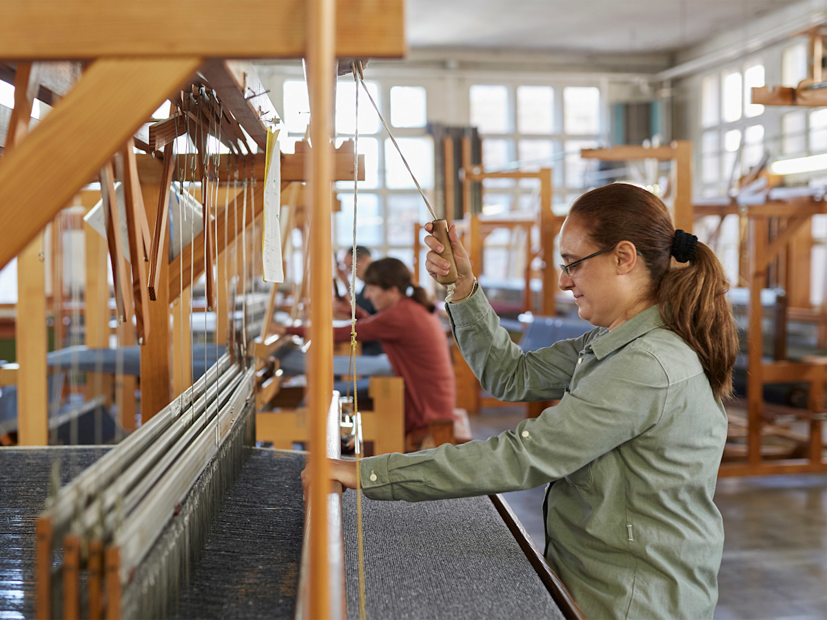 Weavers manually intertwine freshly spun threads 