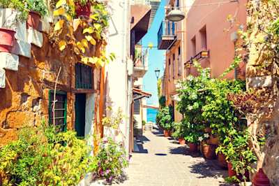 A narrow street with houses and plants in summer in Chania, Crete, Greece