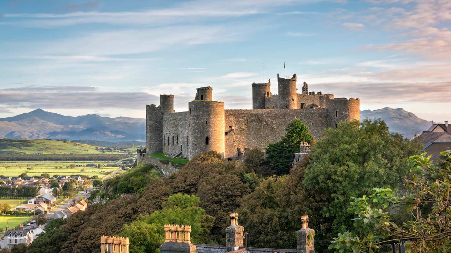 View of Harlech Castle atop a rocky knoll in Gwynedd at sunrise, Wales
