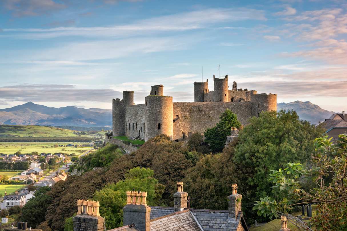 View of Harlech Castle atop a rocky knoll  in Gwynedd at sunrise, Wales