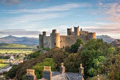 View of Harlech Castle atop a rocky knoll  in Gwynedd at sunrise, Wales