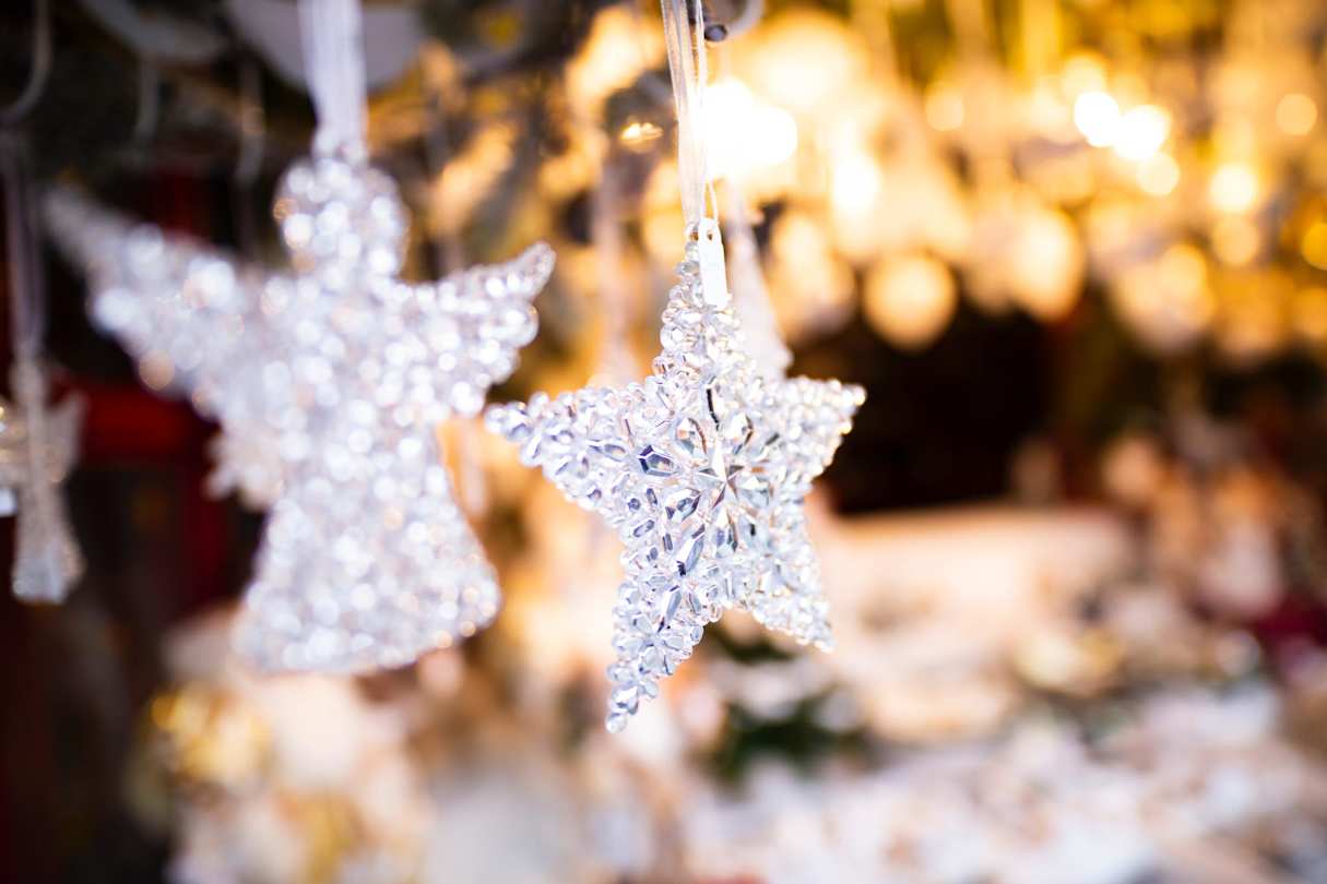 A star ornament and an angel ornament hanging on a Christmas tree