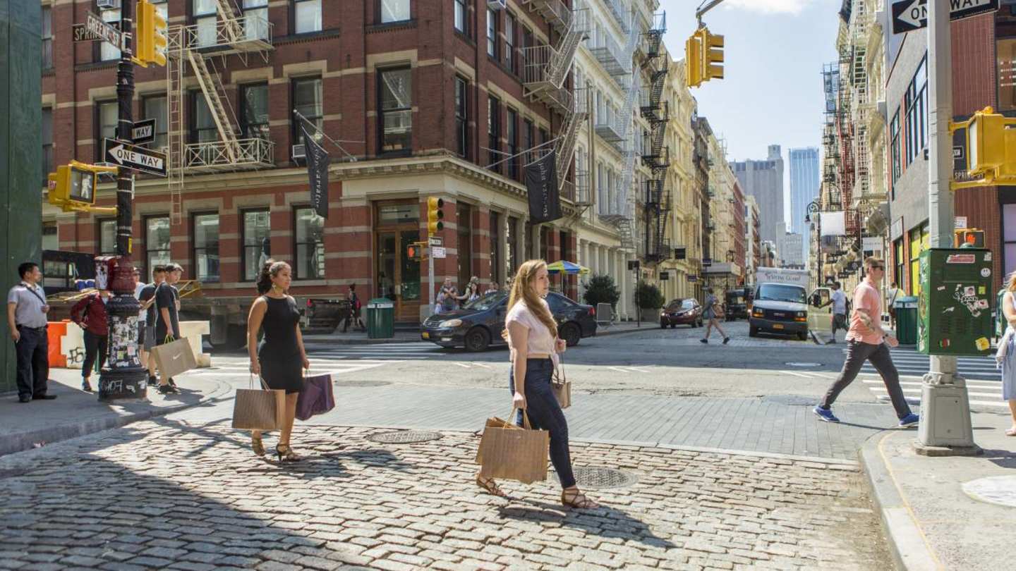 Shoppers walking with bags on a street in New York
