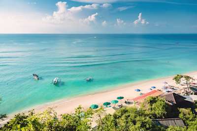 Tropical blue ocean, sandy beach and traditional boats in Indonesia, Bali