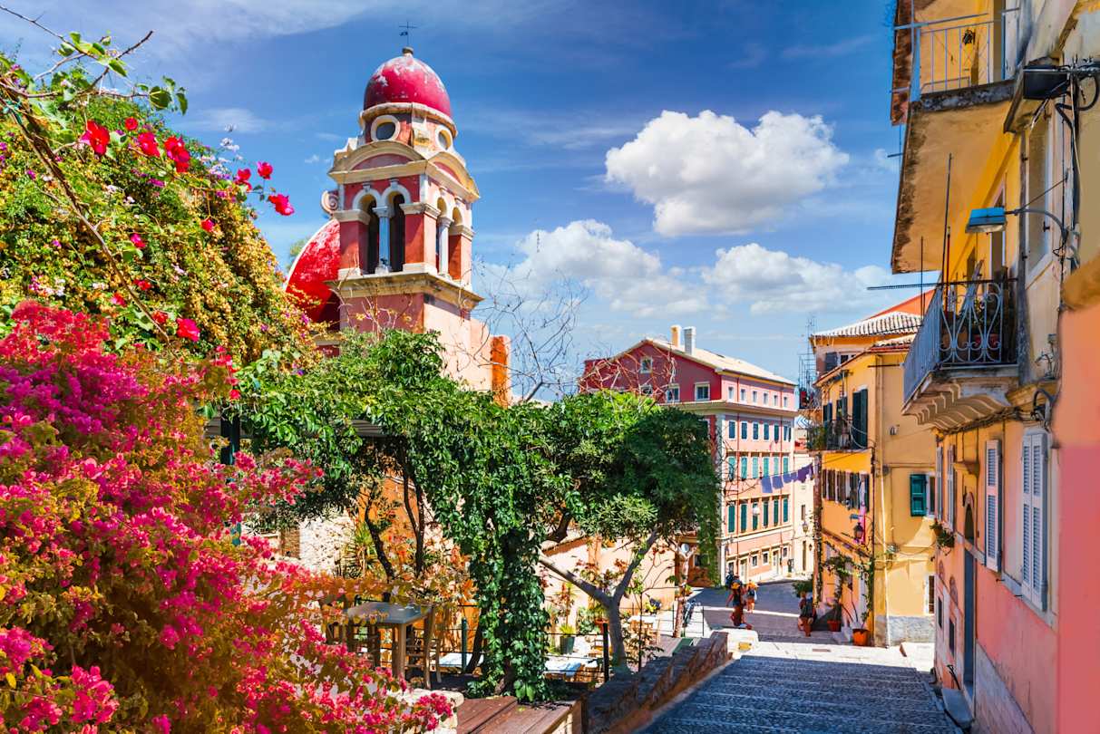 Colourful plants and buildings on a sunny day in Corfu Old Town, Greece