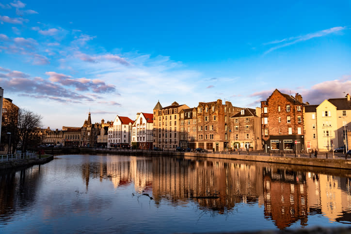 Houses on the banks of the Water of Leith reflected in the water on a beautiful summer's day, Leith, Edinburgh, Scotland
