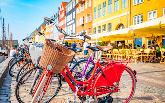 Red bike with a wicker basket in Old Town's Nyhavn harbour, Copenhagen, Denmark